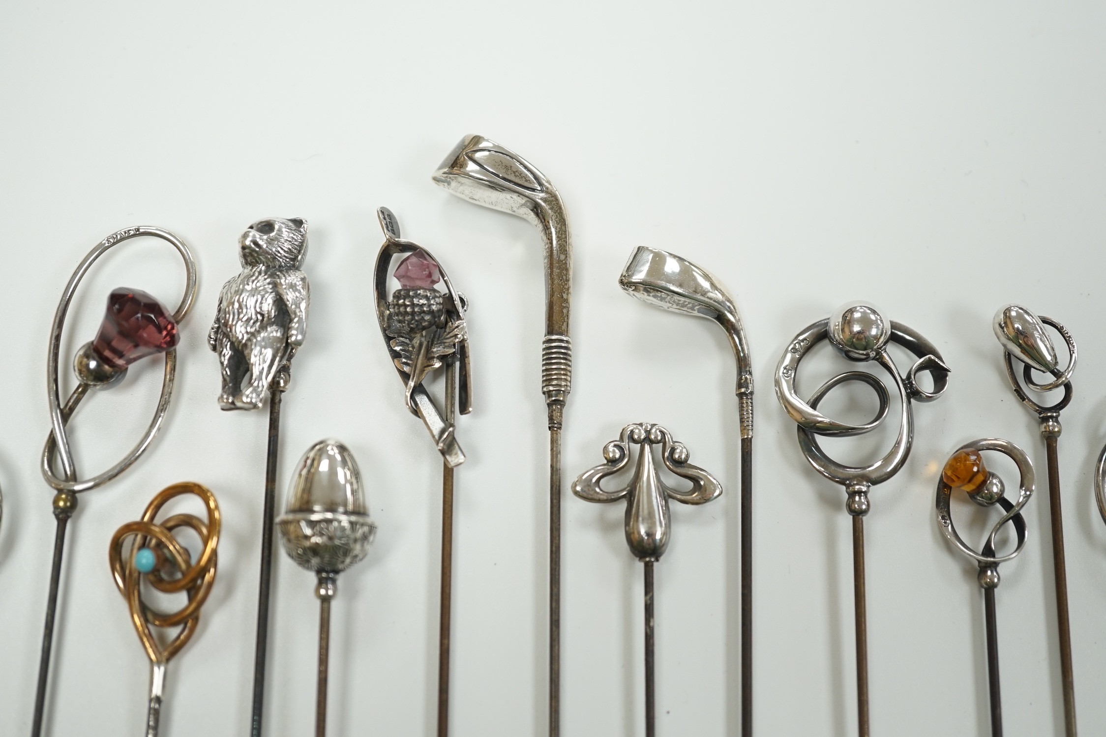 A collection of thirteen assorted early 20th century and later white or yellow metal hat pins, including four by Charles Horner including teddy bear and two silver golf club, longest 31.5cm.